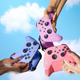 Three hands hold three controllers above a mirror, highlighting their nail polish color.